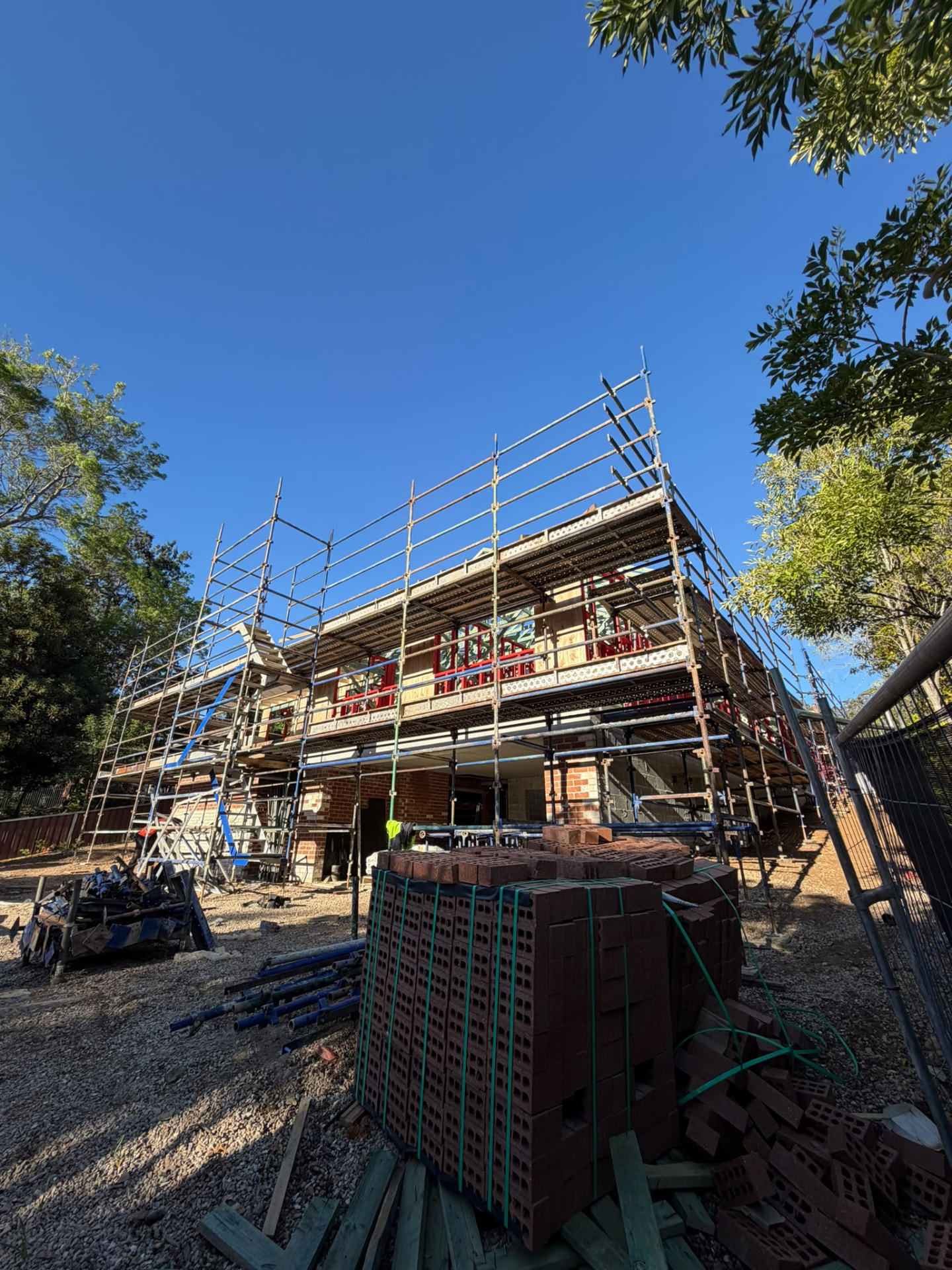 Scaffolding platforms around a two-storey residential build